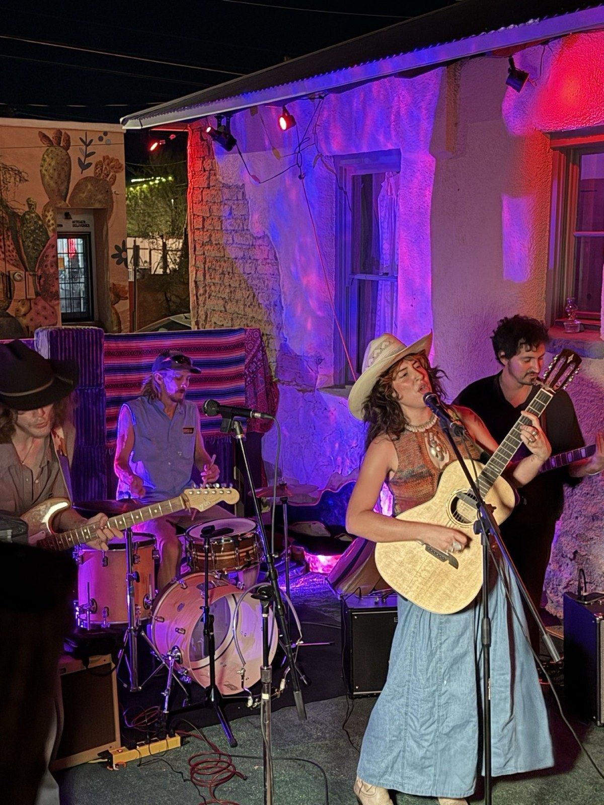 A live band on stage under coloured light