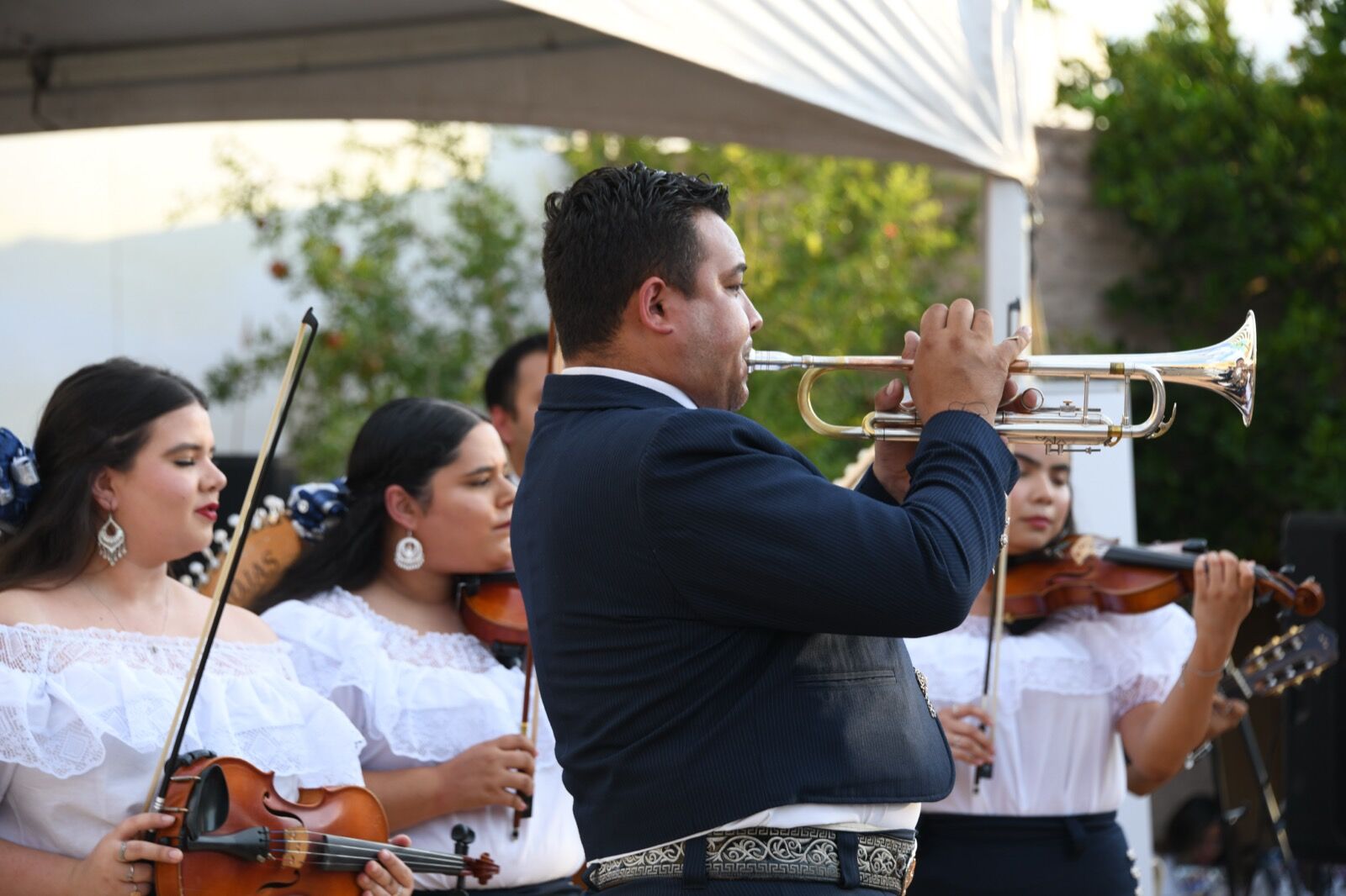 A mariachi with violins and trumpet playing in the courtyard