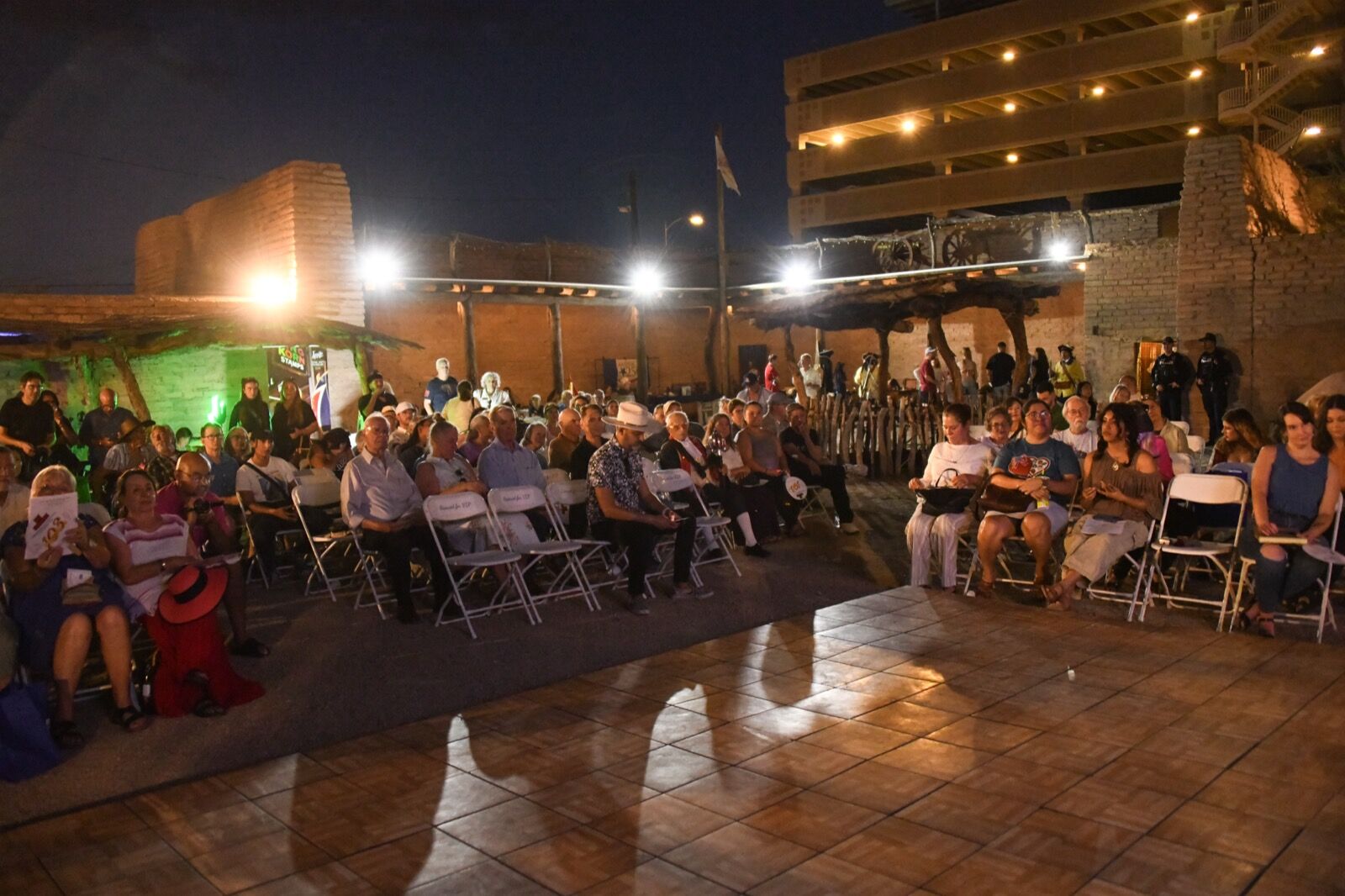The plaza packed with guests after dark under the lights