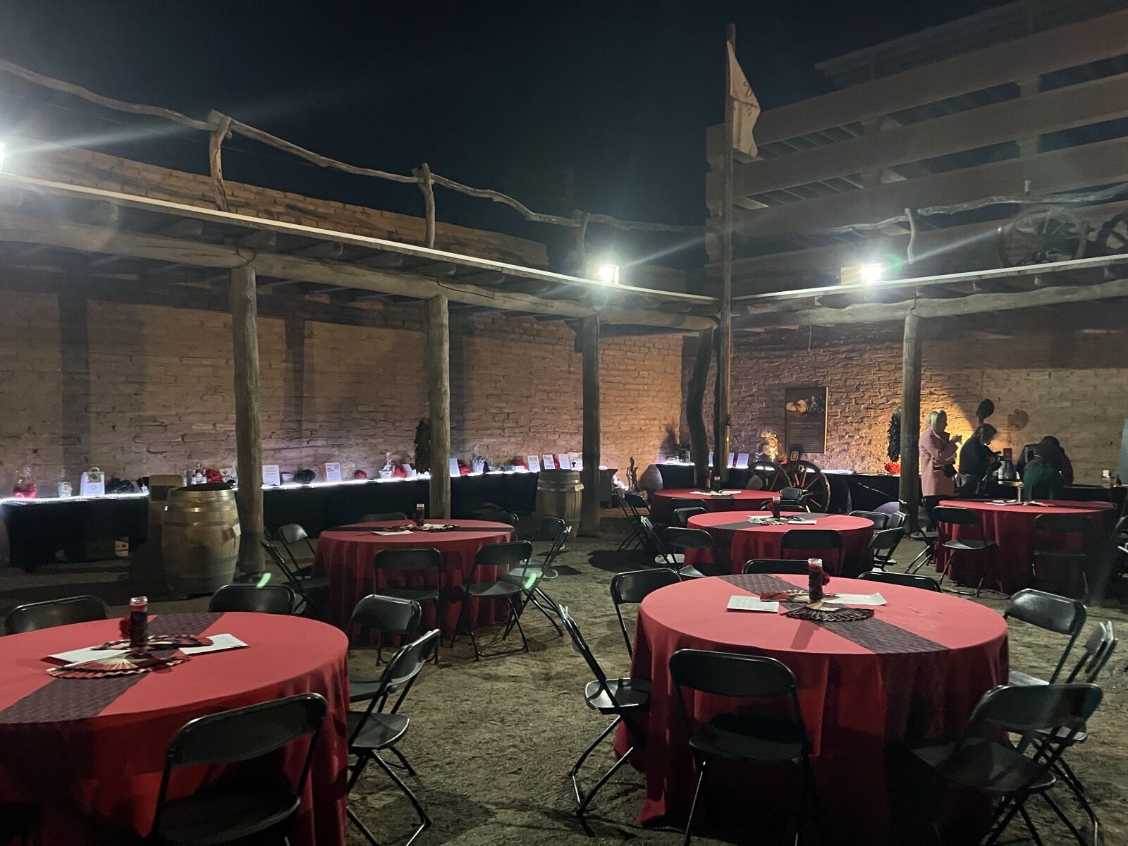 Red-linen round tables set for a dinner on the grounds at night