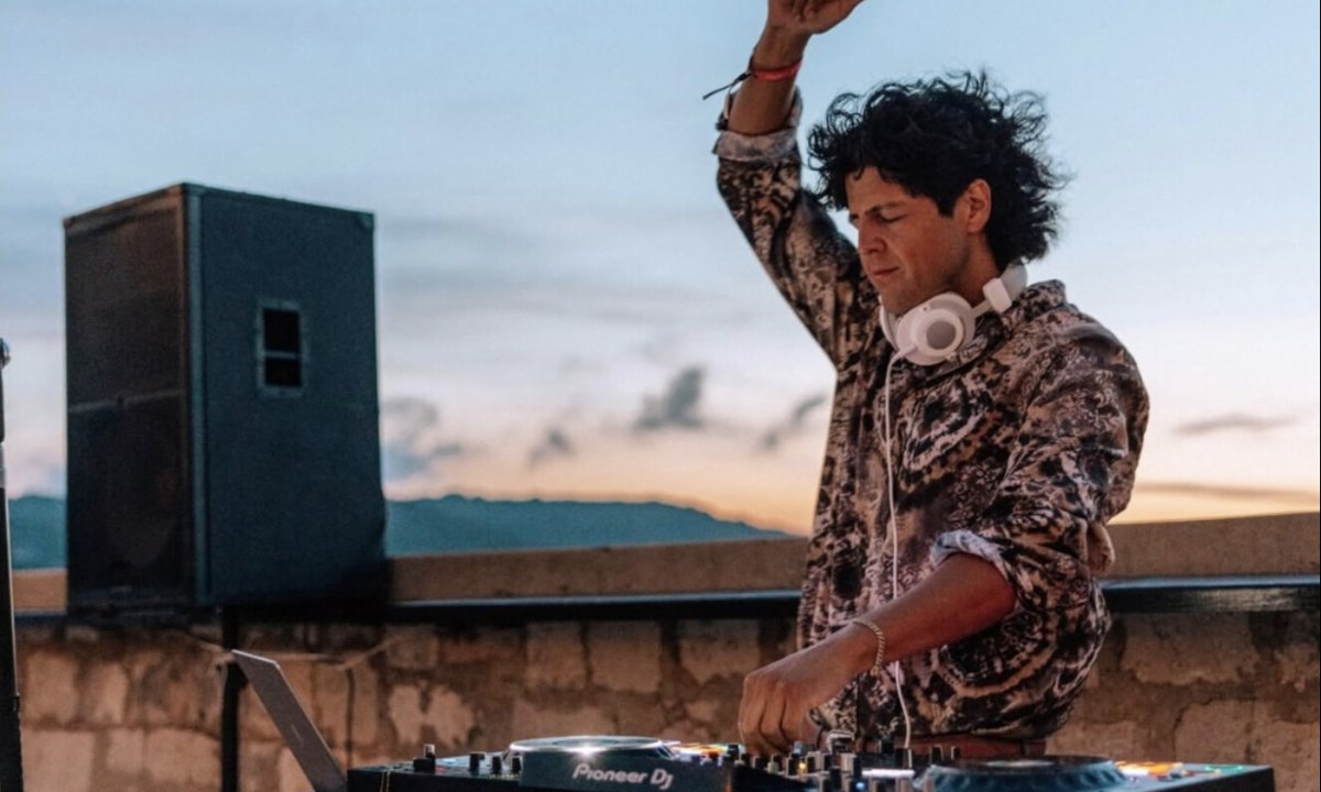 Alexis Walters DJing on Pioneer decks on a stone terrace at sunset